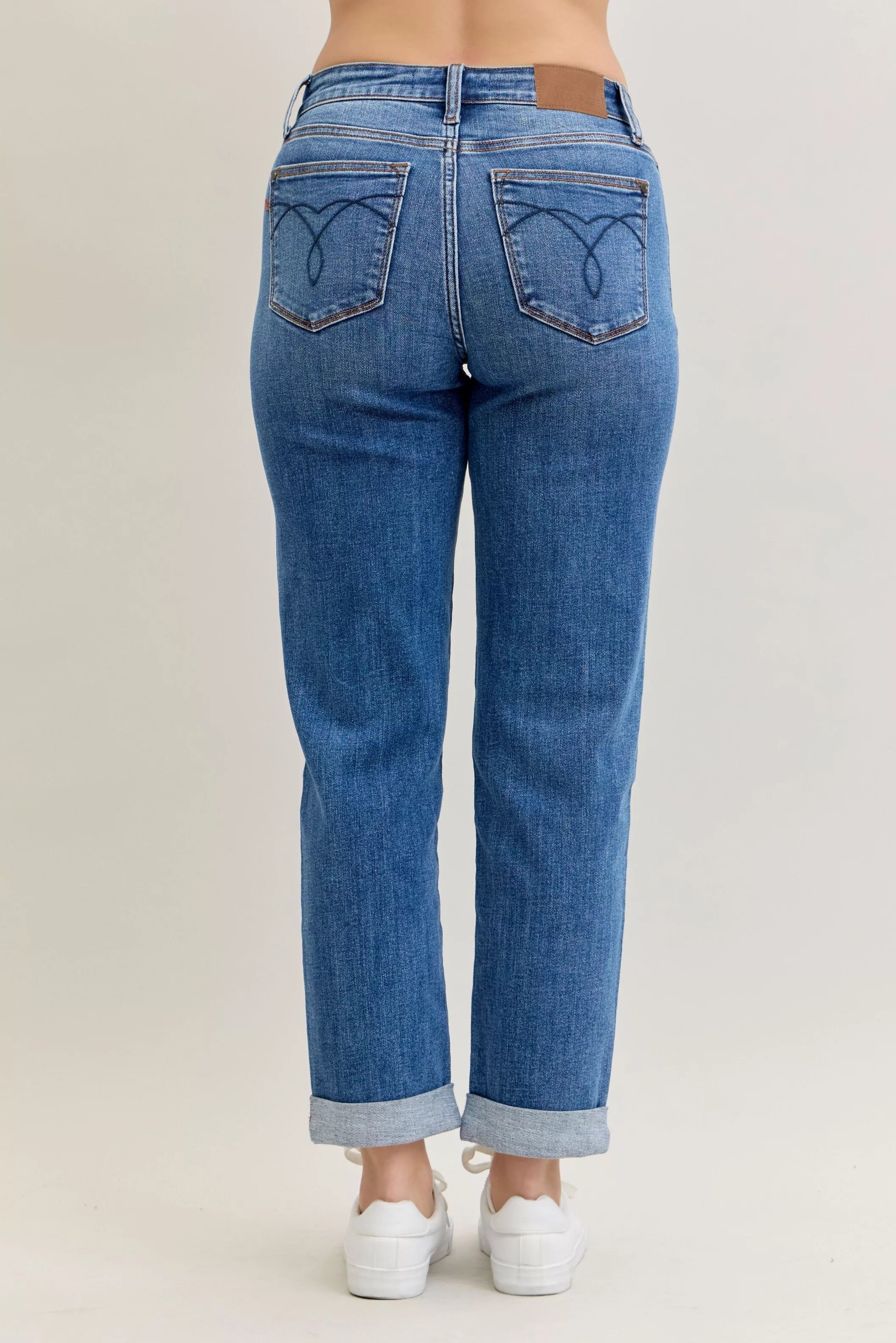 Blue jeans worn by a person on a plain background
