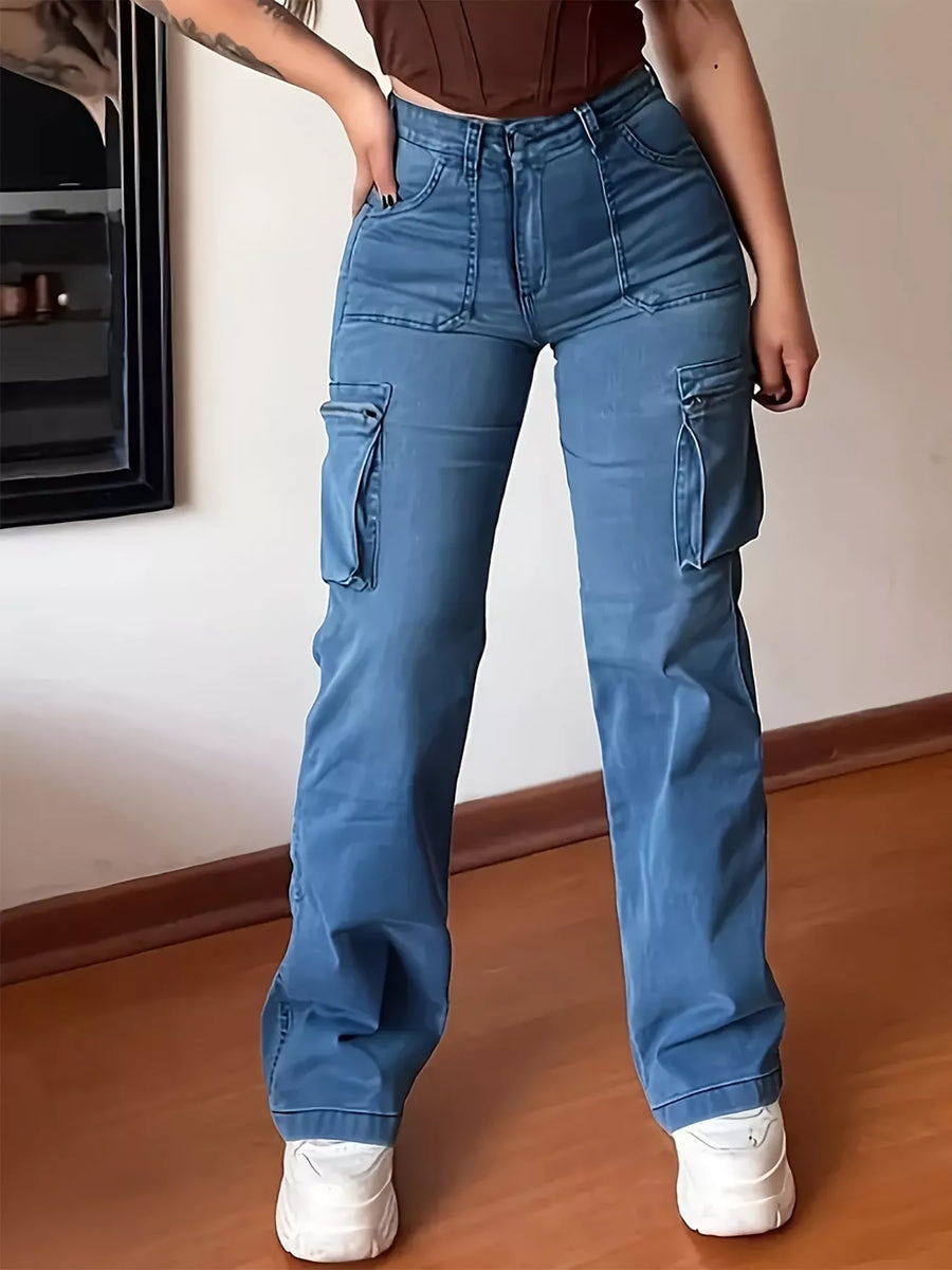 Person wearing blue cargo pants standing indoors on a wooden floor.