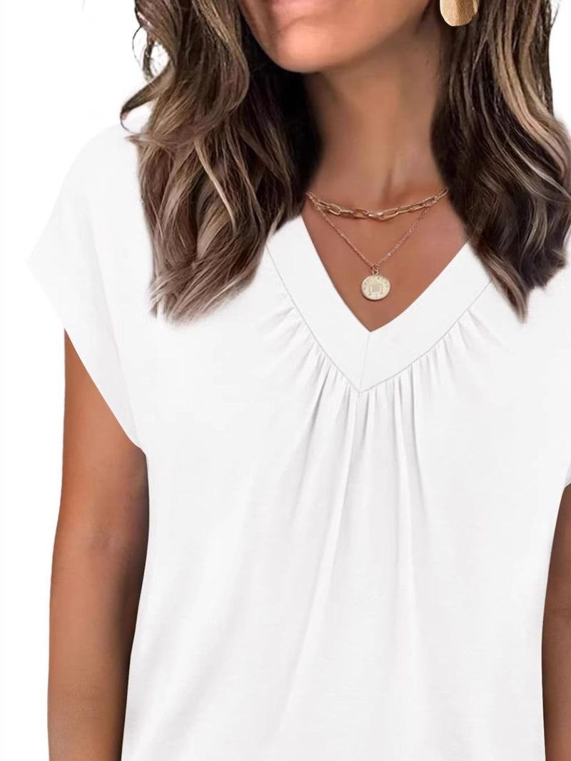 Woman wearing a white top with a plain background