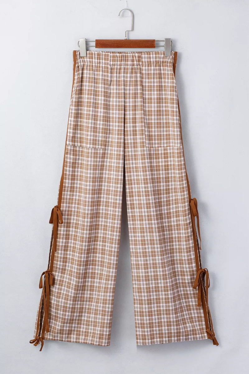 Plaid pants with brown leather straps on a white background