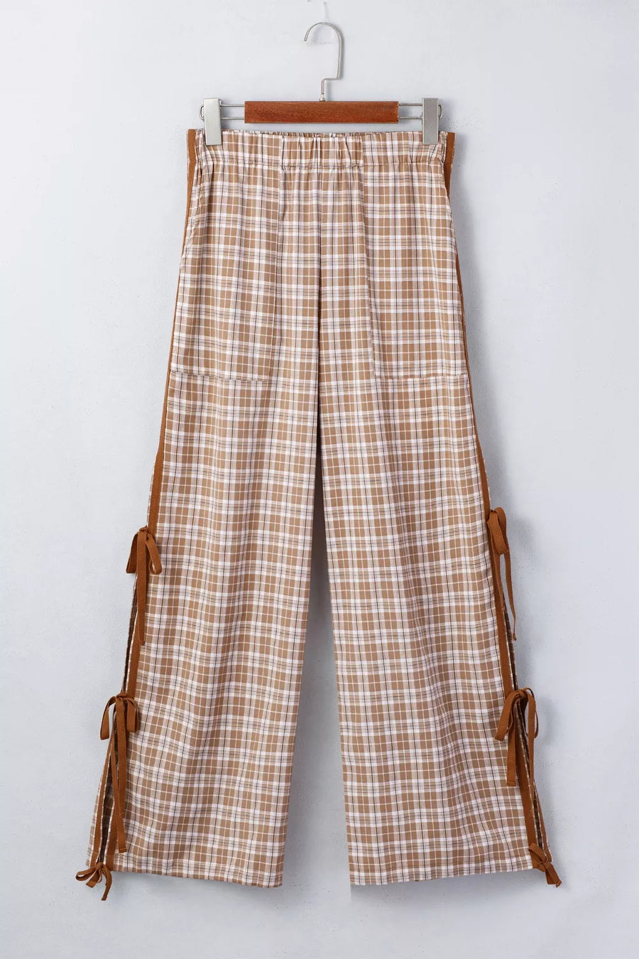 Plaid pants with brown leather straps on a white background