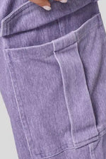 Close-up of a person wearing a purple denim outfit with a focus on the fabric texture.