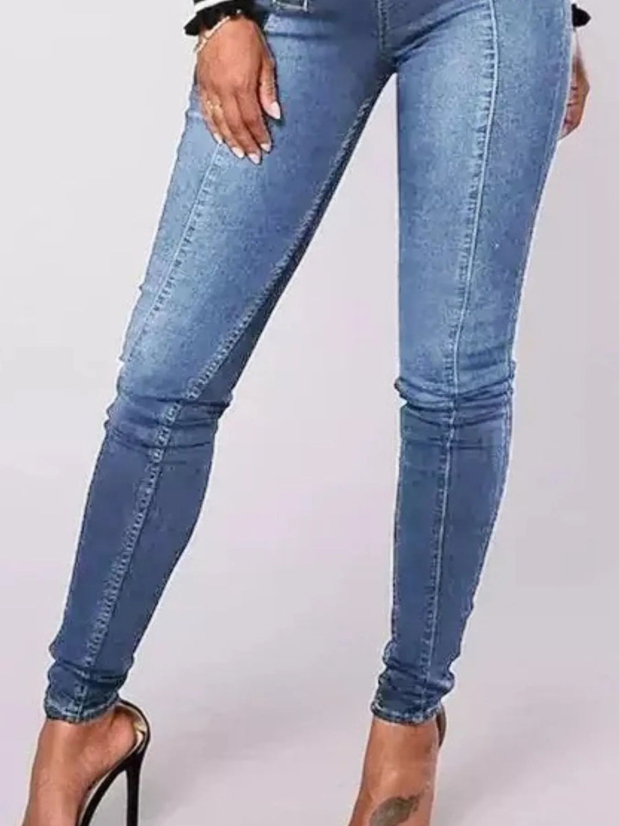Blue jeans worn by a person on a white background