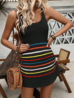 Woman wearing a black sleeveless top and colorful striped skirt with a woven handbag.