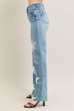 Light blue distressed jeans worn by a person on a plain background