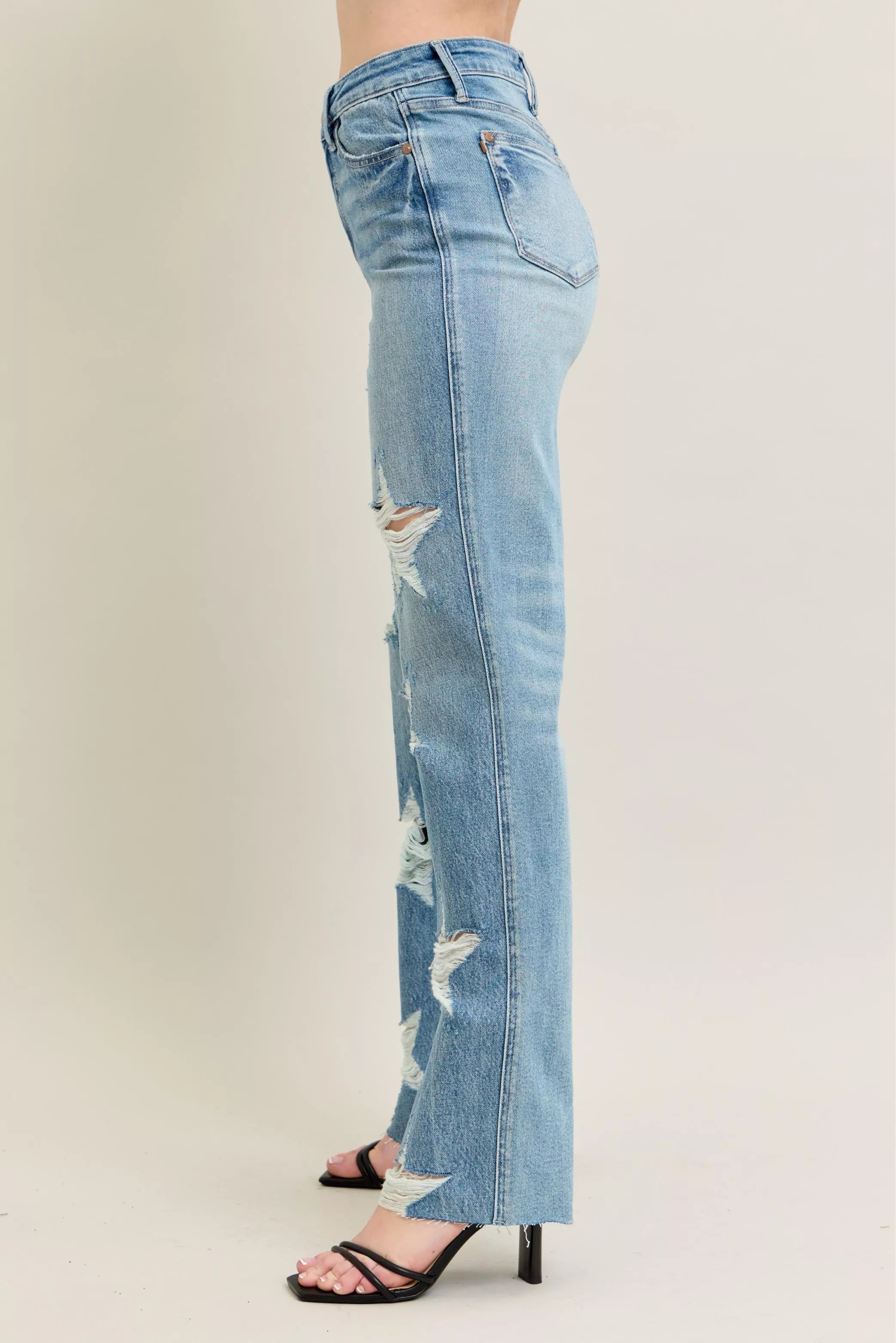 Light blue distressed jeans worn by a person on a plain background