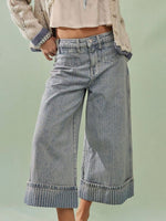 Wide-leg jeans worn by a person on a light green background