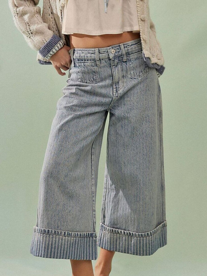 Wide-leg jeans worn by a person on a light green background