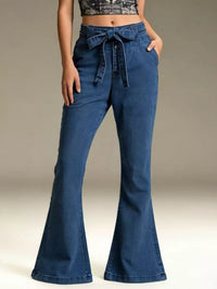 Blue bell-bottom jeans with a tie-waist design on a neutral background