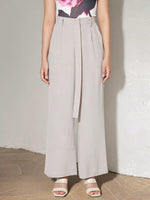 Person wearing light gray wide-leg pants against a plain background