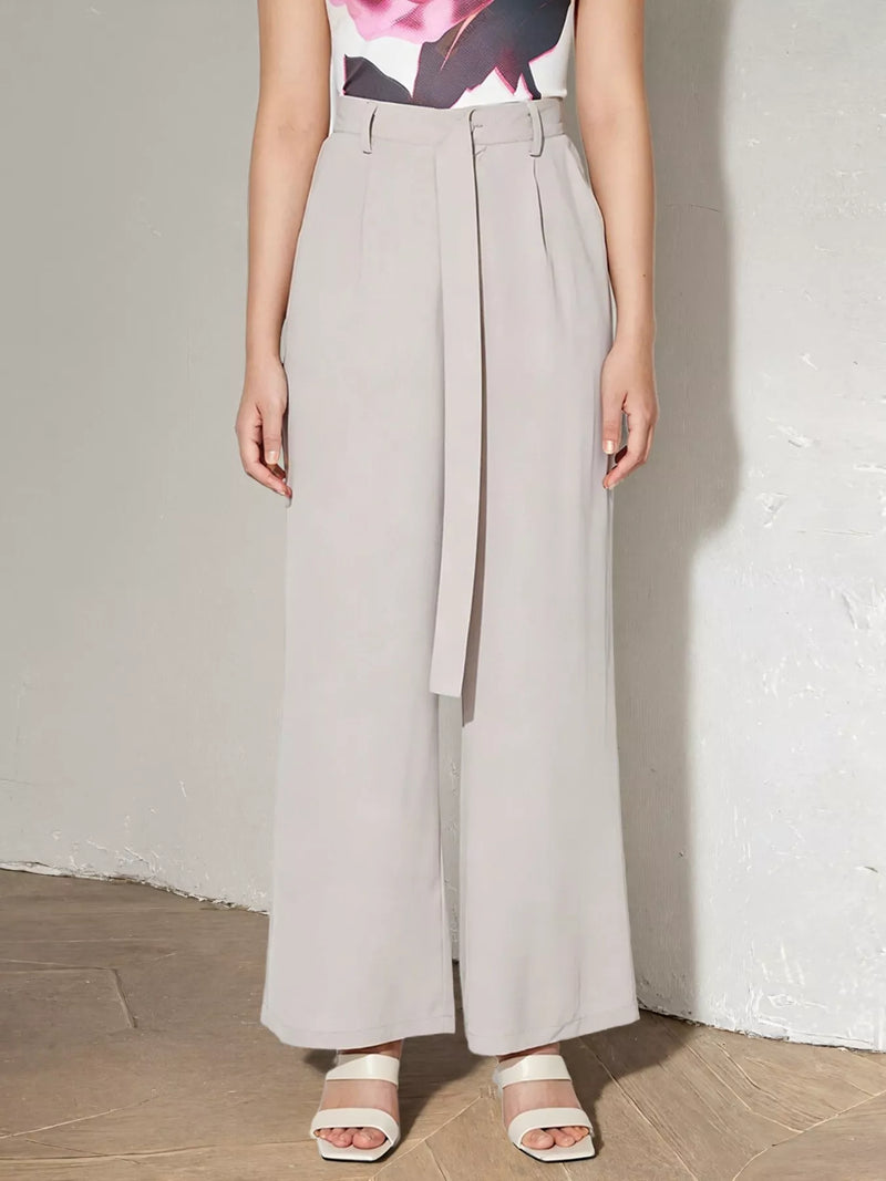Person wearing light gray wide-leg pants against a plain background