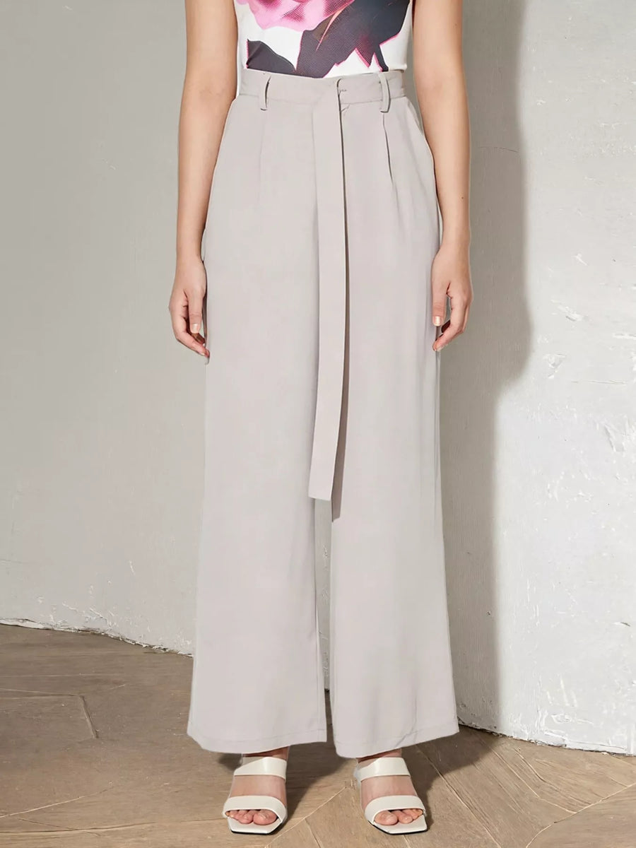 Person wearing light gray wide-leg pants against a plain background
