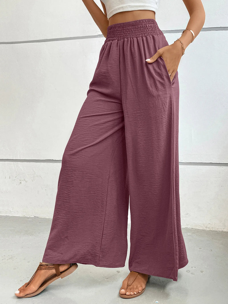 Person wearing mauve wide-leg pants with a white background