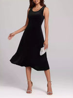 Woman wearing a black sleeveless dress on a plain background