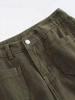 Close-up of green pants with a button and pocket on a white background