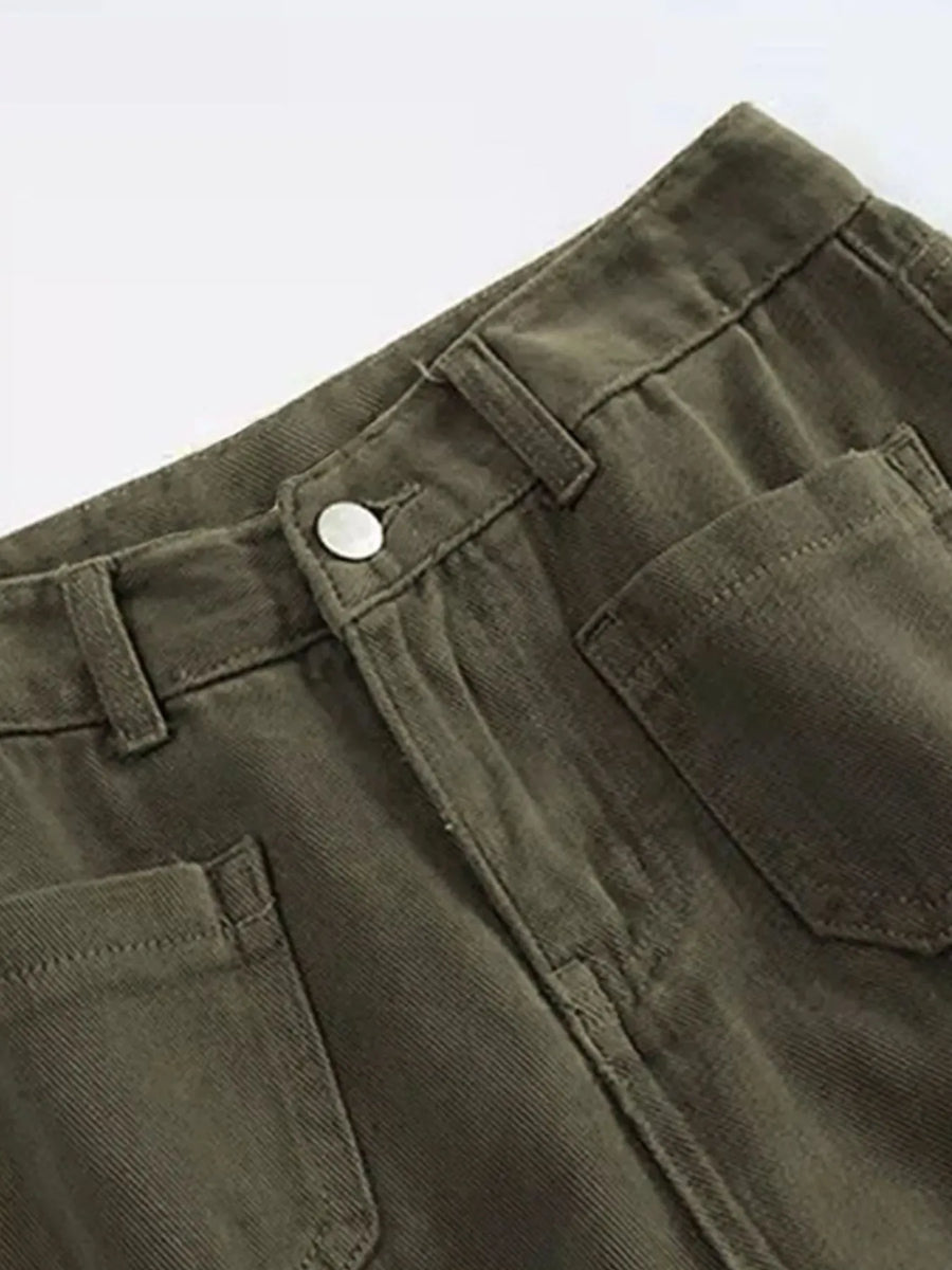 Close-up of green pants with a button and pocket on a white background