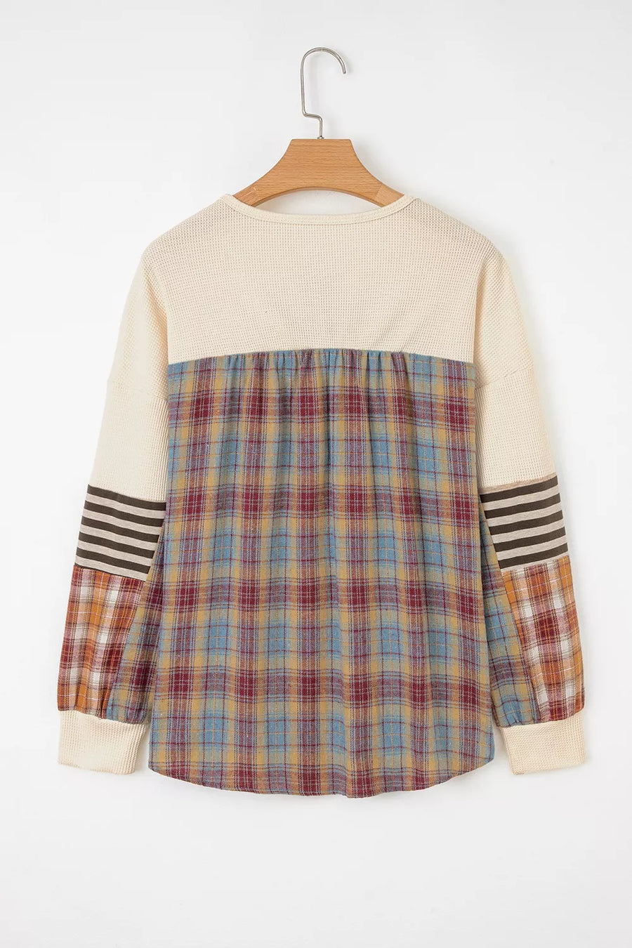 Plaid shirt with striped sleeves on a hanger against a white background