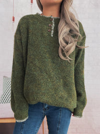 Green sweater worn by a person with a neutral background