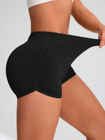 Person wearing black shorts on a plain background
