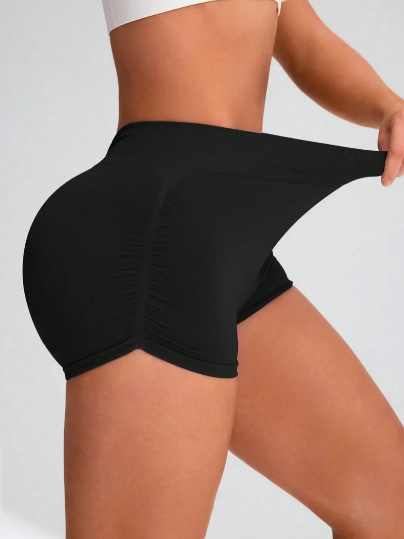 Person wearing black shorts on a plain background