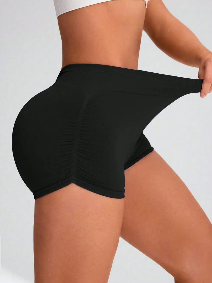Person wearing black shorts on a plain background