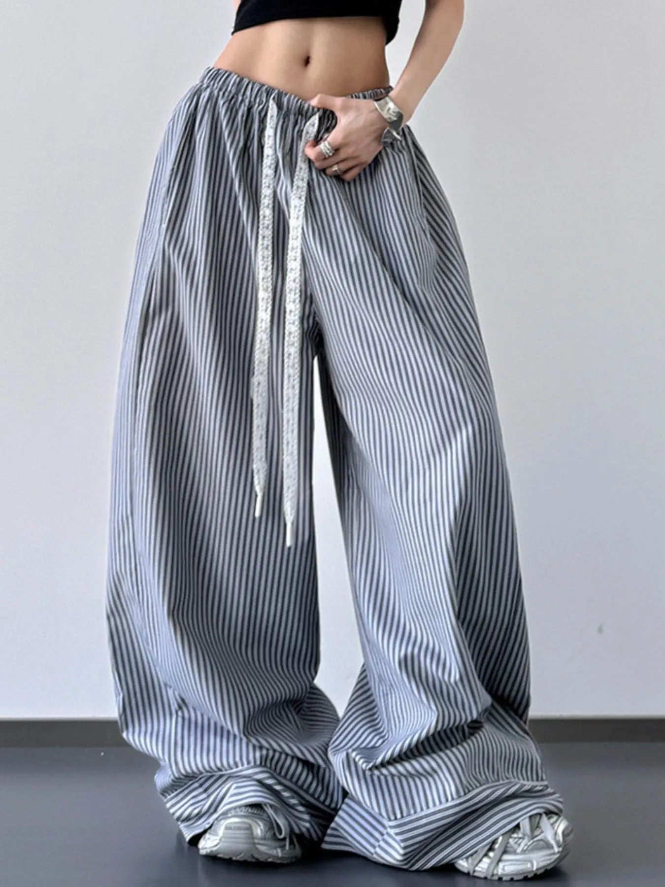 Person wearing wide-leg striped pants with a plain background