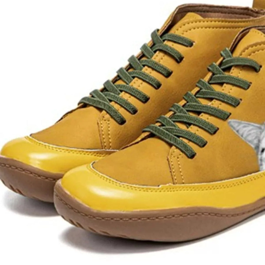 Yellow sneakers with green laces on a white background
