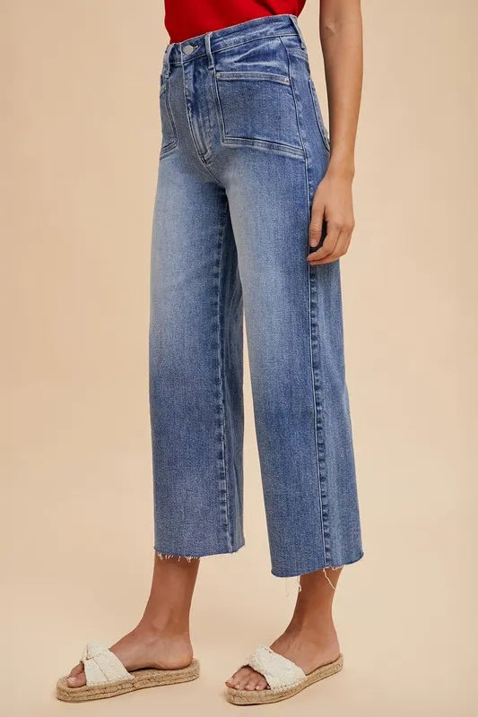 Person wearing blue jeans on a beige background