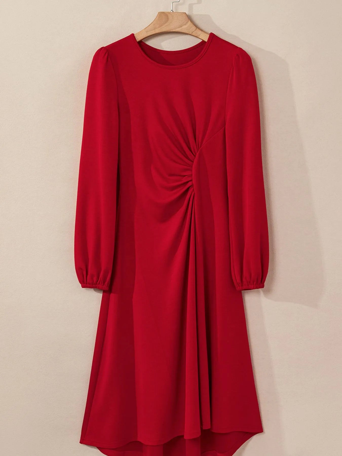 Red dress with long sleeves on a beige background