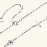 Silver anklets with heart, triangle, and cross charms on a white background