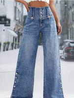 Wide-leg jeans with decorative buttons on a blurred street background