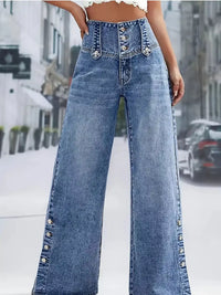Wide-leg jeans with decorative buttons on a blurred street background