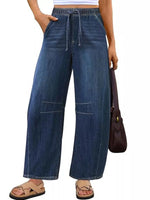 Person wearing wide-leg blue jeans on a white background