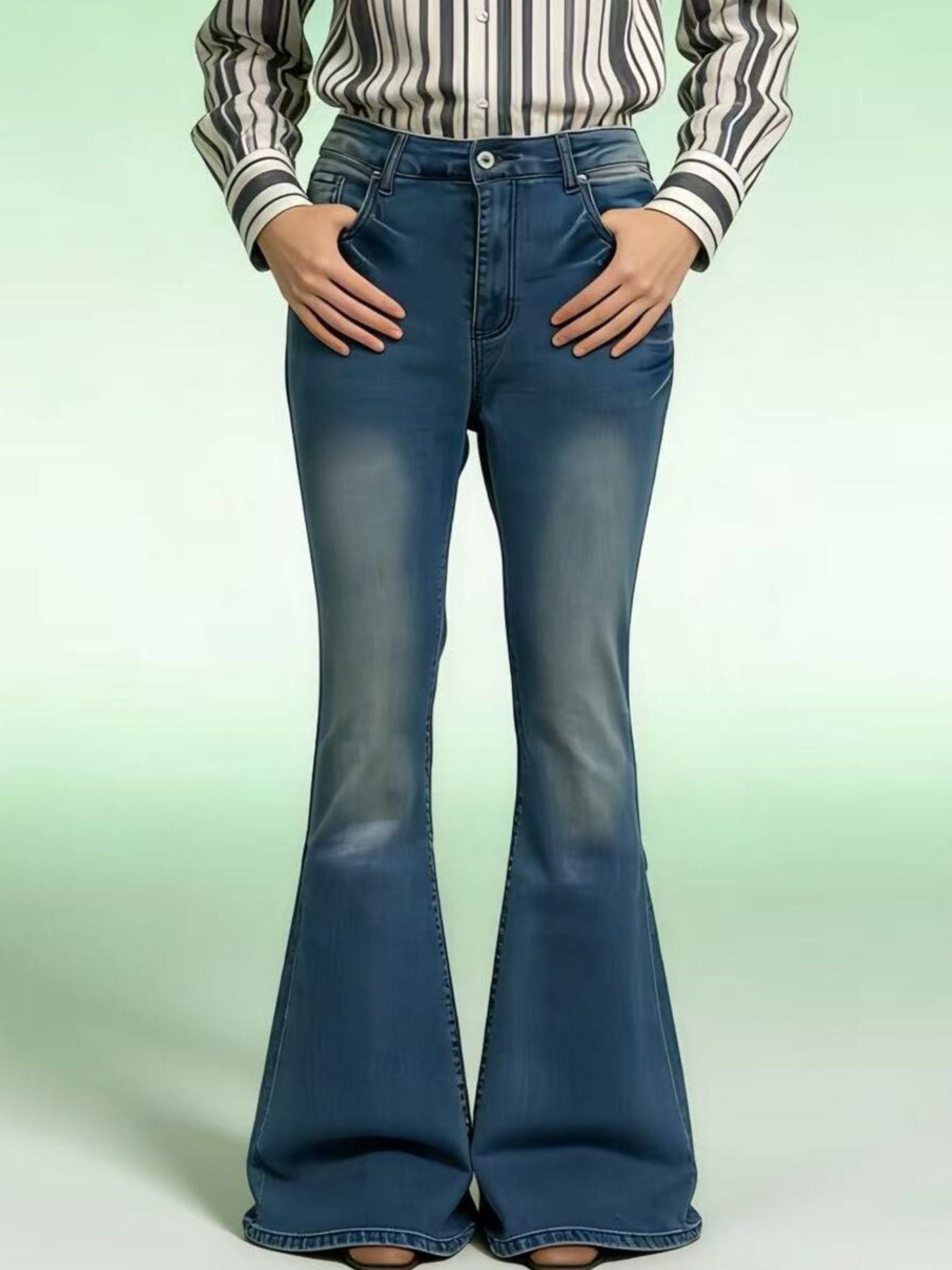 Person wearing blue bell-bottom jeans with a striped shirt on a light green background