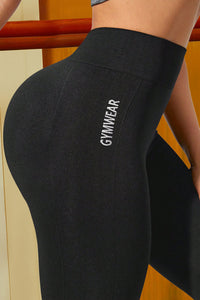 Black gymwear leggings with 'GYMWEAR' text on a neutral background