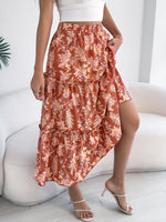 Person wearing a floral skirt sitting on a white couch.
