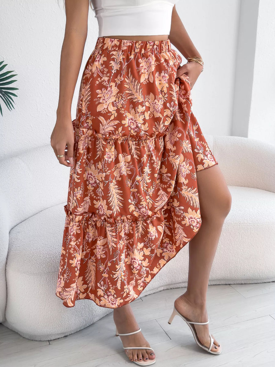 Person wearing a floral skirt sitting on a white couch.