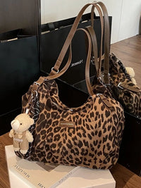 Leopard print handbag with a teddy bear charm on a magazine