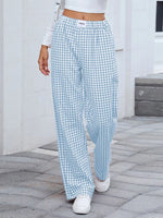 Person wearing blue and white checkered pants on a stone pavement.