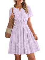 Woman wearing a light purple dress holding a brown bag on a white background