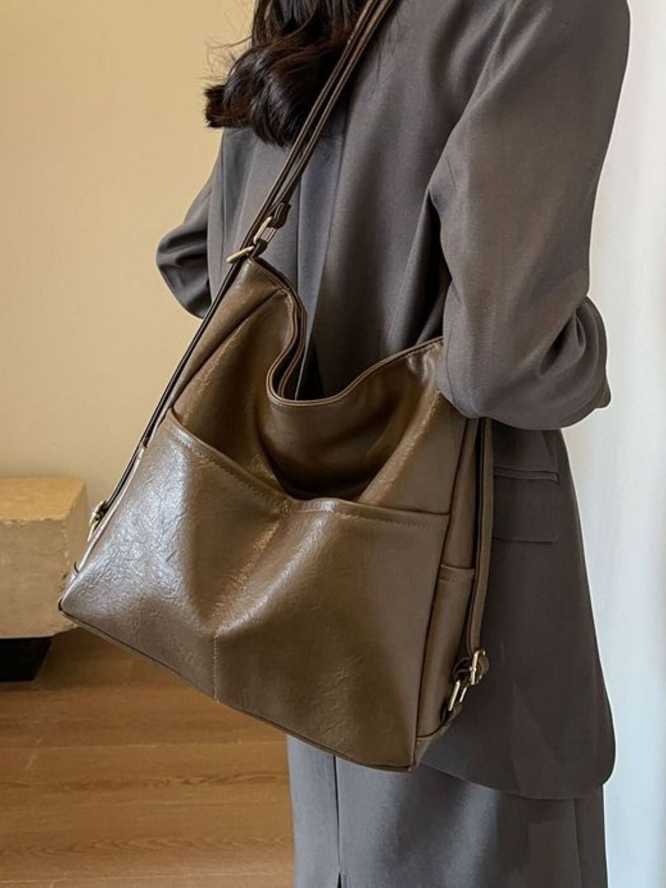 Person wearing a brown leather handbag indoors