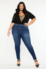 Woman wearing blue jeans and a black top with a leopard print design on a white background