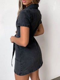 Woman wearing a black denim dress against a white background
