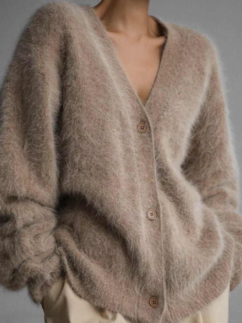 Close-up of a fluffy brown cardigan with buttons on a neutral background