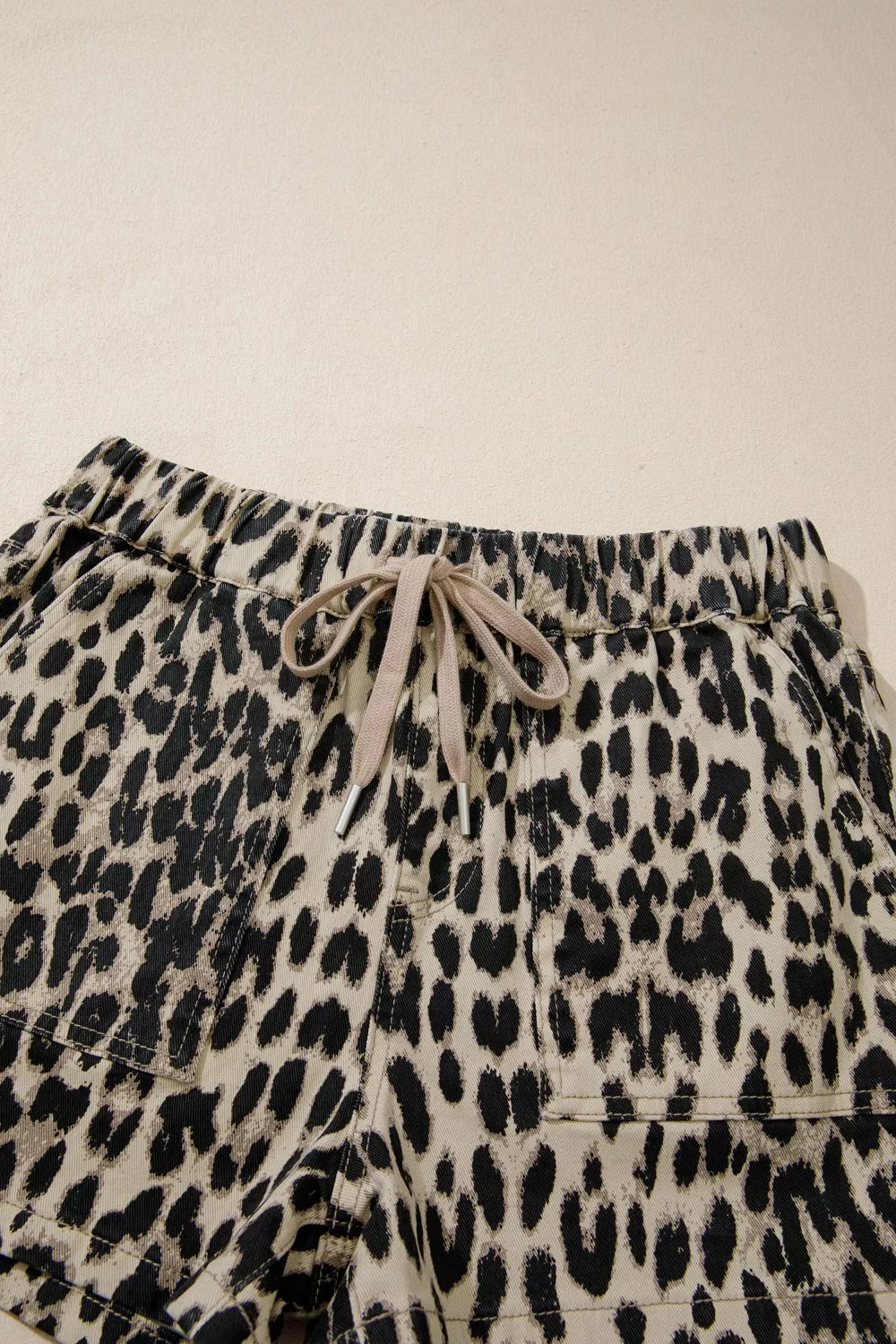 Leopard print shorts with drawstring on a beige background