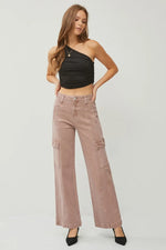 Woman wearing a black halter top and pink cargo pants on a white background