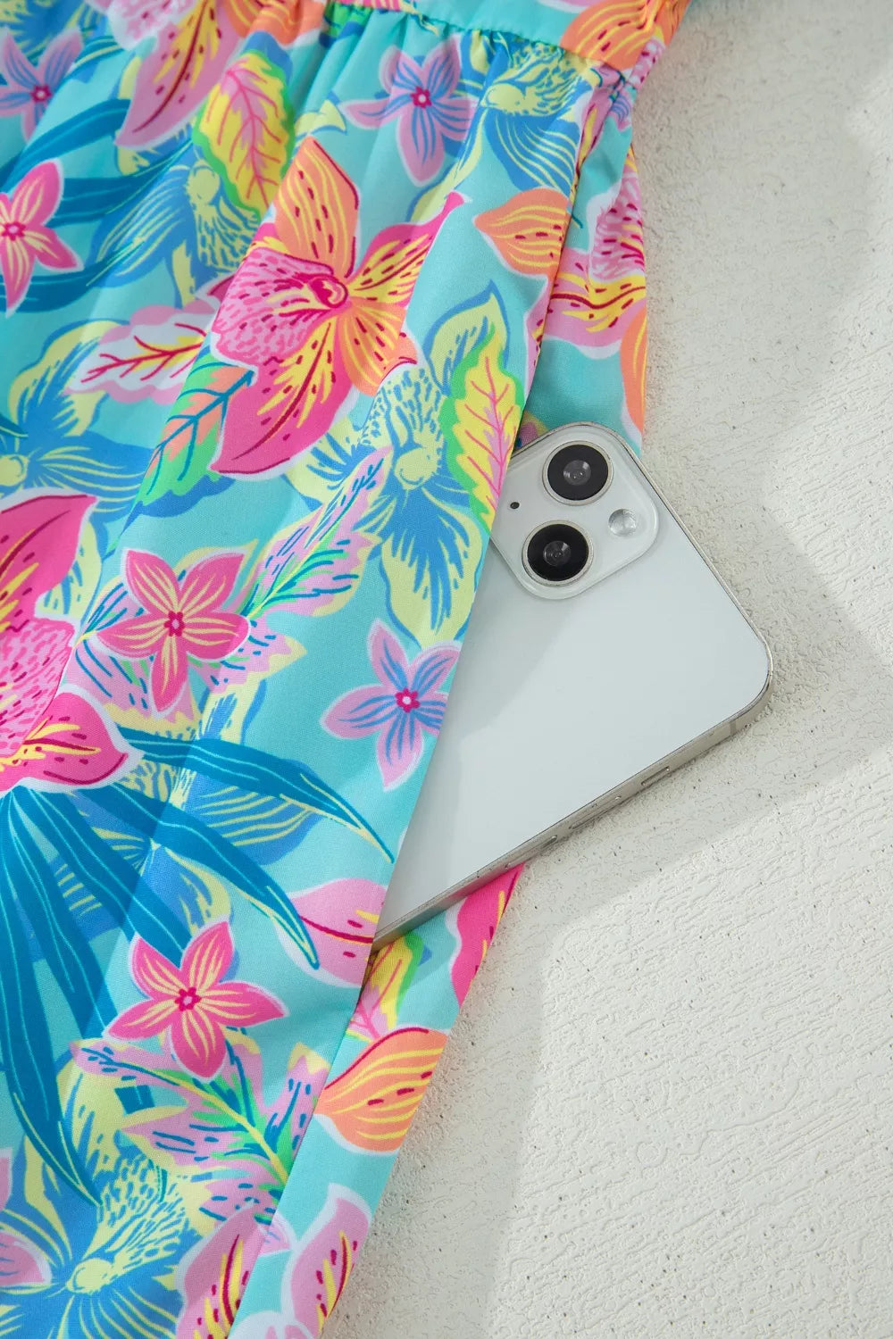 Phone case with colorful floral pattern on a sandy background