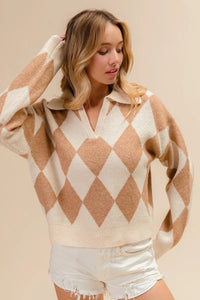 Woman wearing a beige and white argyle sweater with white shorts on a beige background