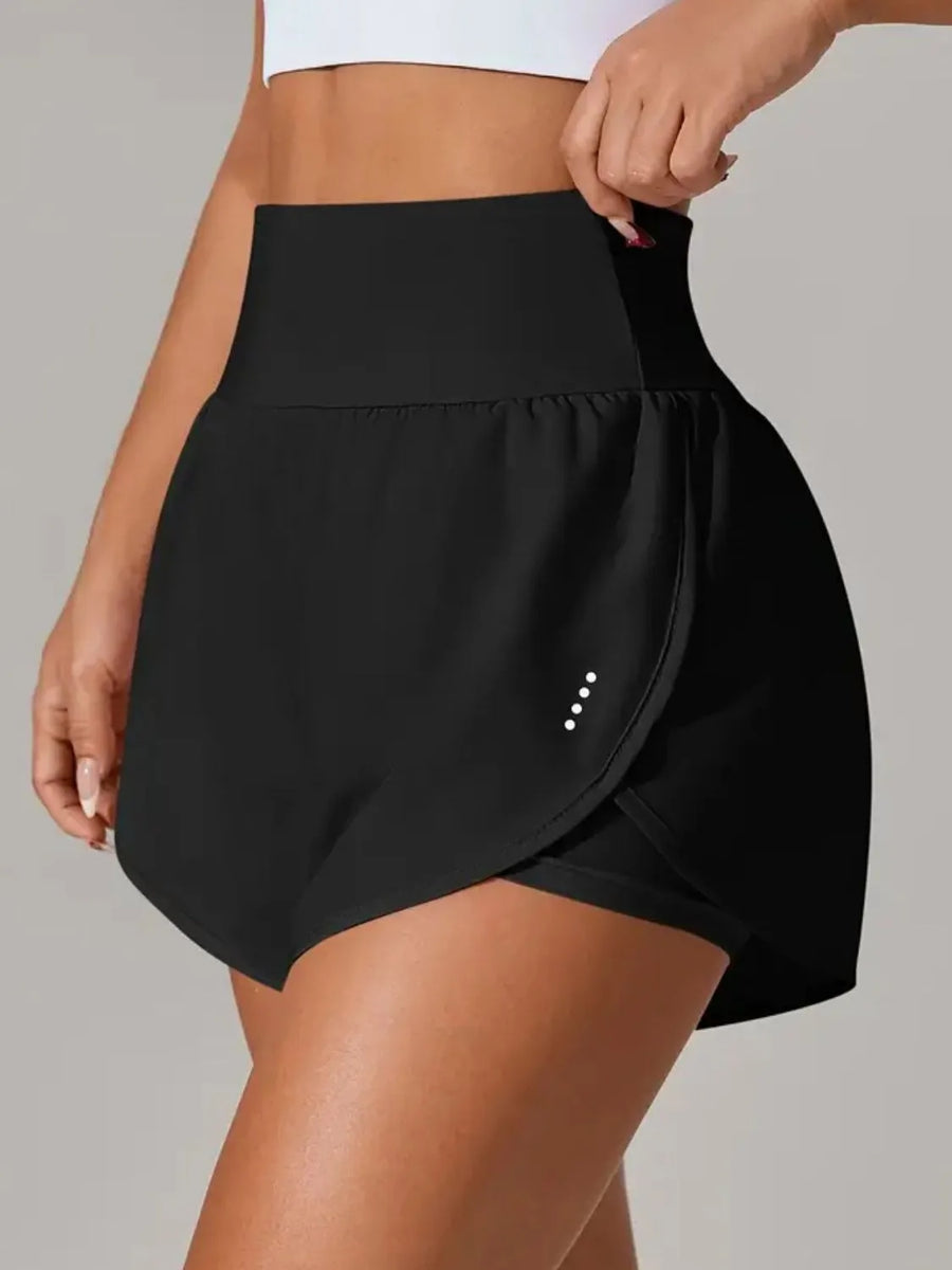 Black athletic skirt worn by a person on a gray background