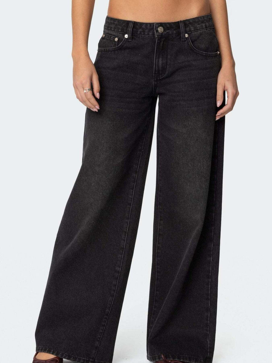 Black wide-leg jeans worn by a person on a white background